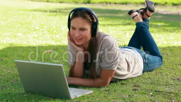 在她面前拿着笔记本电脑听音乐的女人视频的预览图
