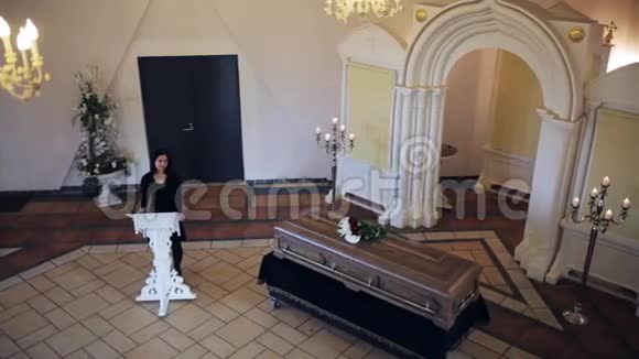 在东正教教堂举行的葬礼上悲伤的女人和棺材视频的预览图