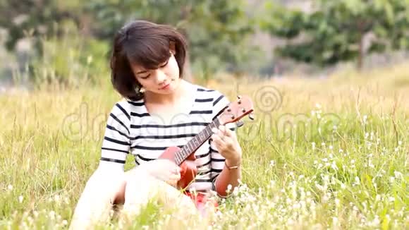 亚洲年轻人拥抱她的四弦琴视频的预览图
