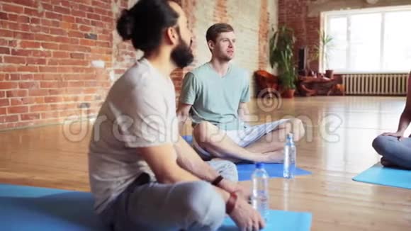 有水的男人躺在健身房的瑜伽垫上视频的预览图