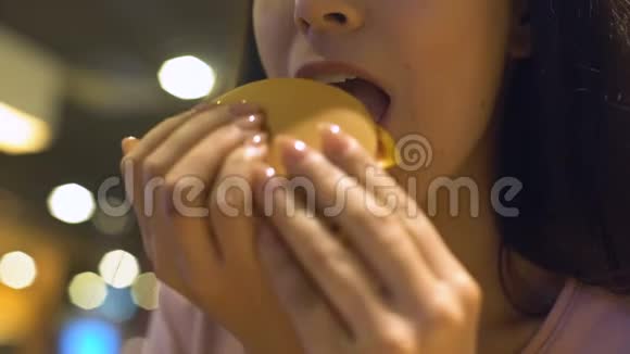 年轻女人吃垃圾食品汉堡微笑美味的不健康的饭菜视频的预览图
