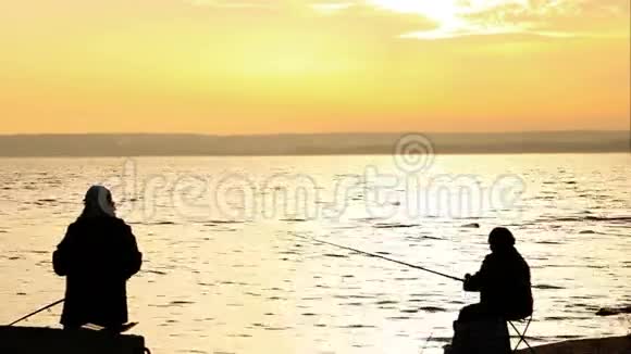 渔民在平静的日落海边视频的预览图