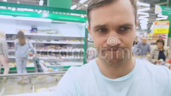 在超市里一位丈夫的脸特写她期待着妻子在商店购物无聊无聊视频的预览图