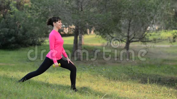 运动的白种人妇女在公园里做体重训练视频的预览图