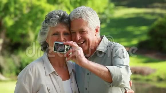 微笑着的成熟的情侣拍照视频的预览图