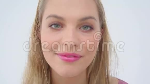 金发女人在嘴唇上涂上唇彩视频的预览图