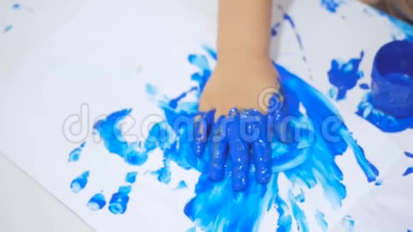 一个小女孩在画画时把她的手和衣服弄脏了幼儿仔细检查脏手视频的预览图