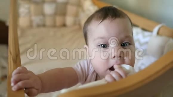小有趣的女孩站在婴儿床上笑快乐童年概念视频的预览图
