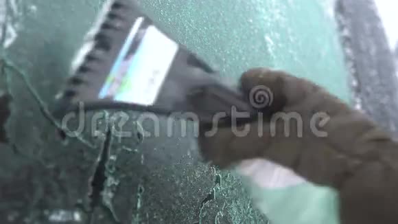 年轻女子在车上擦雪和冰冬季暴风雪视频的预览图