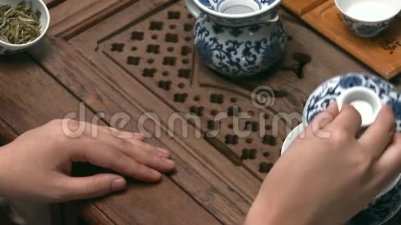 中国茶道由茶道大师表演中国茶道女性手在杯子里倒茶视频的预览图