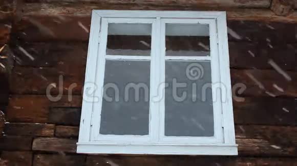 在旧木屋背景的窗户上缓慢地下雪视频的预览图