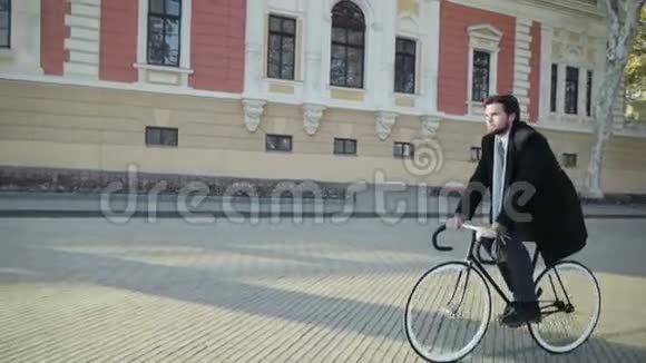 英俊的商人在旧城骑自行车视频的预览图