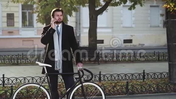 站在自行车旁的商人在打电话视频的预览图