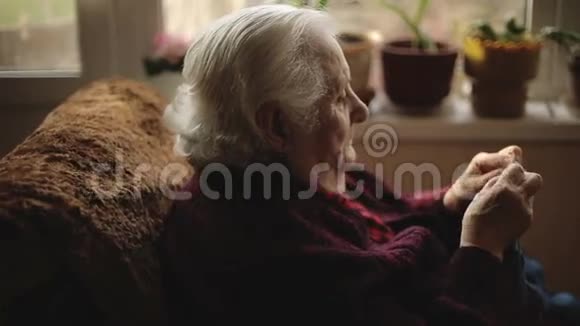 这位老妇人坐在家里编织衣服视频的预览图