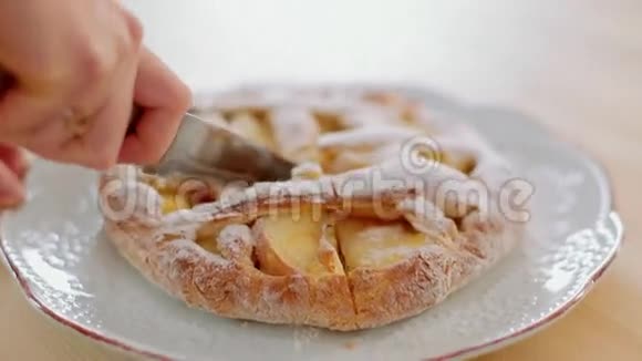 女孩用锋利的菜刀切新鲜烤苹果派视频的预览图