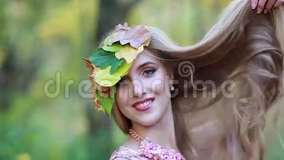 年轻的女孩秋天的叶子和长长的美丽的头发秋姑娘视频的预览图