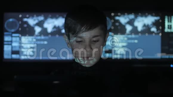 年轻的天才黑客程序员在数据中心的电脑上工作里面装满了显示屏肖像视频的预览图