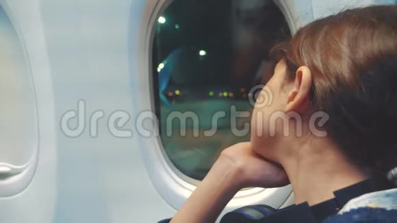 少女航空飞机概念年轻女孩看着坐在窗边的飞机生活方式之夜的航班视频的预览图