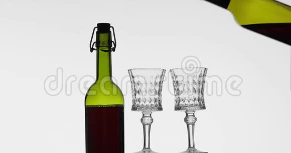 玫瑰酒红酒在白色背景下倒入两个酒杯视频的预览图