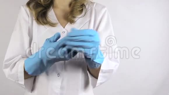 医生白色制服揭开无菌橡胶蓝色手套视频的预览图