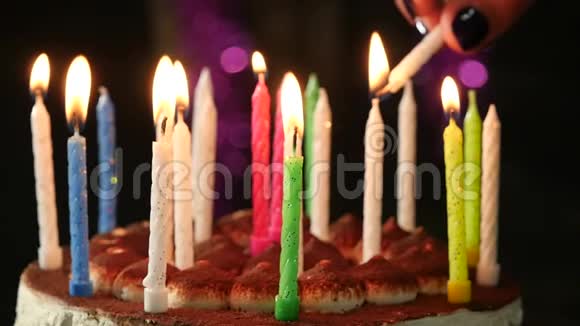女人在美味的生日蛋糕上点燃蜡烛慢动作视频的预览图