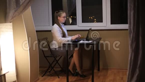 疲惫的商务女性戴着眼镜深夜在办公室笔记本电脑里工作在深夜学习熬夜视频的预览图