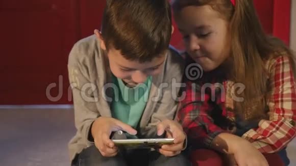 儿童在圣诞树附近玩手机儿童和智能手机视频的预览图
