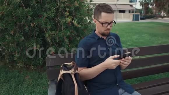 使用智能手机坐在长凳上的人视频的预览图