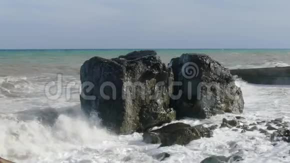 暴风雨中海滩上巨大的巨石特写视频的预览图