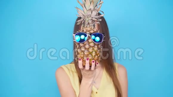 快乐的年轻女人拿着菠萝视频的预览图