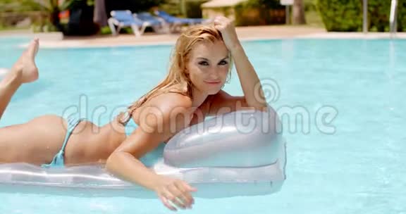 躺在游泳池里的漂浮床垫上的女人视频的预览图