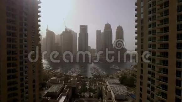 阿联酋迪拜的摩天大楼之间有游艇和堤岸的美丽海景视频的预览图