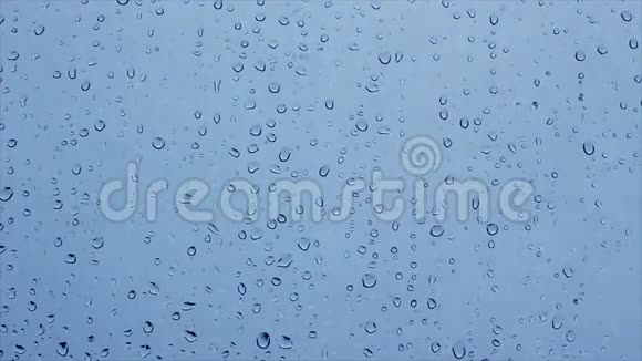 雪和水滴在蓝色背景上的窗户玻璃上的时间推移云层通过视频的预览图