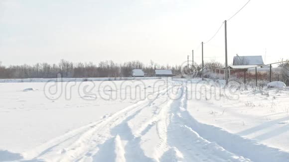俄罗斯村庄阳光明媚的冬天白雪覆盖的道路视频的预览图