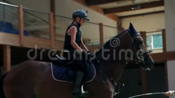 年轻女孩骑马和男性教练学习视频的预览图