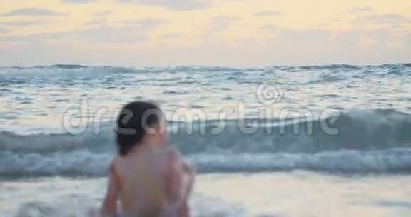 小女孩在海滩上玩海浪视频的预览图