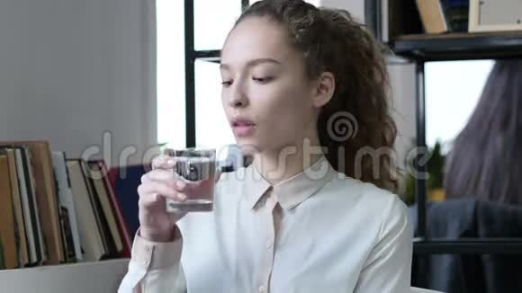 女人在玻璃里喝水坐在办公室里视频的预览图