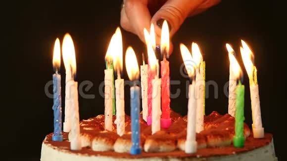 女人在美味的生日蛋糕上点燃蜡烛慢动作视频的预览图