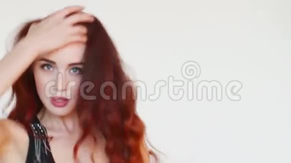 穿着红头发的女人在白色工作室跳舞视频的预览图