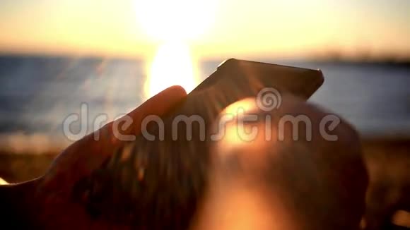 人类的双手在海边使用移动智能手机视频的预览图
