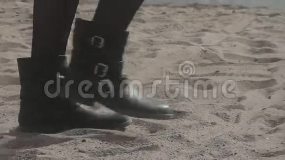 穿着黑鞋在沙滩上散步的女孩的修长的腿视频的预览图