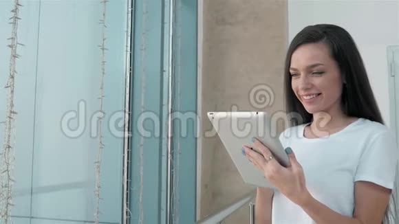 美丽的年轻女学生在购物中心使用她的白色平板电脑快乐的大学生活视频的预览图
