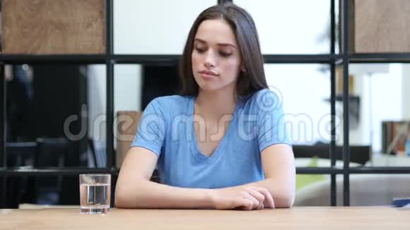 女人喝水坐在办公室里视频的预览图