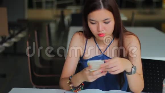 不快乐无聊的泰国成人美丽的阅读信息在智能手机上视频的预览图