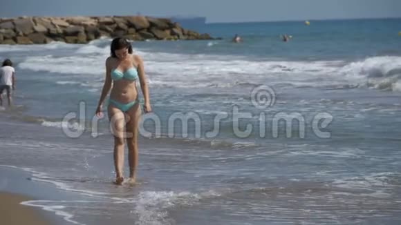 穿着泳衣的女孩在海边慢动作地奔跑视频的预览图