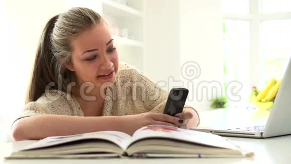 少女在笔记本电脑上学习时发送短信视频的预览图
