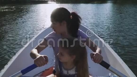 母亲和女儿在船上划船视频的预览图