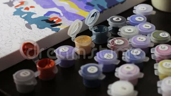根据数字用丙烯酸颜料作画许多彩色颜料在罐子里作画视频的预览图