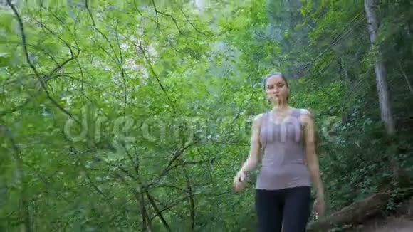 旅行者妇女在山上的森林小径上徒步旅行在岩石上行走视频的预览图