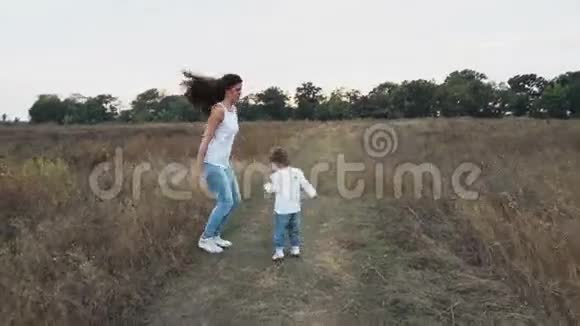 在秋天的田野上快乐地跳跃着母女视频的预览图